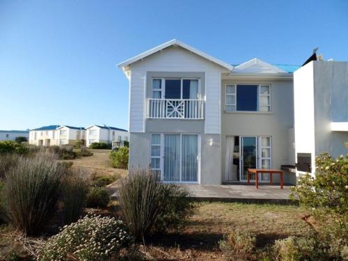 a white house on the beach with condos at Pinnacle Point Lodge 81 in Mossel Bay