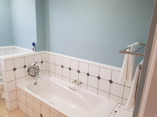 uma banheira branca numa casa de banho com azulejos brancos em Pinnacle Point Lodge 81 em Mossel Bay