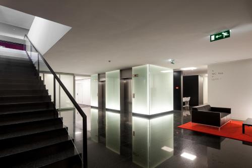 a lobby with a staircase and a stair case at Hotel 3K Europa in Lisbon