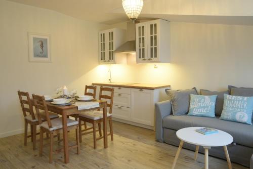 una cucina e un soggiorno con un tavolo e un divano di Seaside Apartamenty Puck a Puck