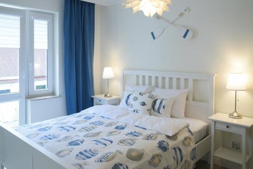 una camera da letto con un letto e una finestra con tende blu di Seaside Apartamenty Puck a Puck