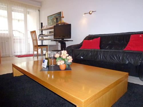 un soggiorno con divano nero e tavolino da caffè di Panorama Studio Apartment a Castagnola