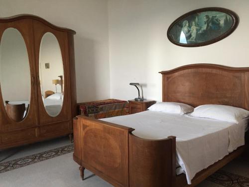 1 dormitorio con cama de madera y espejo en Casa Marina, en Vietri