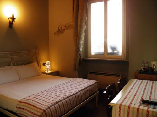 um pequeno quarto com uma cama e uma janela em In Centro Charme em Bérgamo