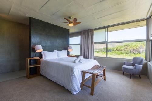 a bedroom with a bed and a large window at Red Box Villa in Plettenberg Bay