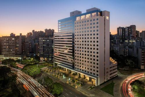 a tall white building in a city with traffic at Intercity Porto Alegre Cidade Baixa in Porto Alegre