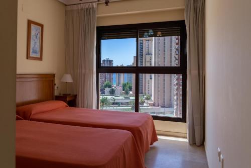 una camera da letto con un letto e una grande finestra di Gemelos 20 - Beninter All Inclusive a Benidorm