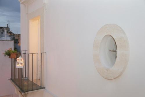 a white wall with a clock on a balcony at Sottacastieddu in Avetrana