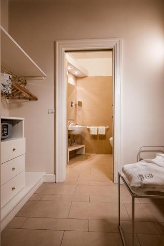 a bedroom with a bathroom with a sink and a mirror at Hotel & Residenza 100 Torri in Ascoli Piceno