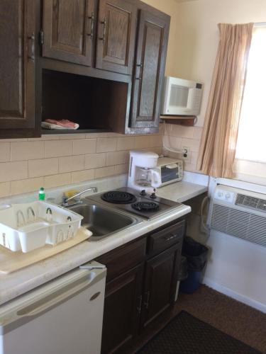 a kitchen with a sink and a microwave at Crystal Sands Motel in Wildwood