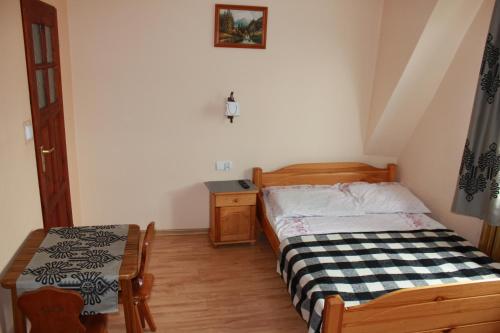 a small bedroom with a bed and a table at Ośrodek Wczasowy Panorama in Bukowina Tatrzańska