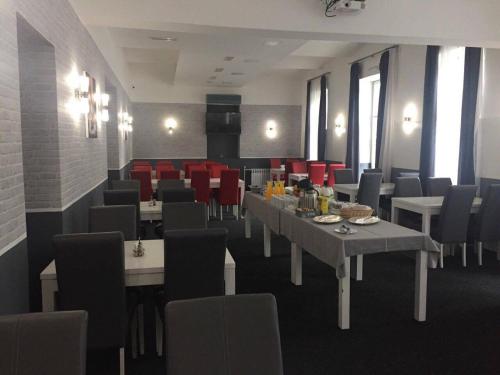 a dining room with tables and chairs and red chairs at Hostel Levicki in Slavonski Brod