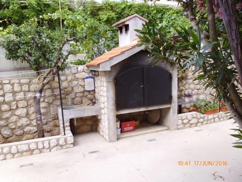 a dog house in a stone wall at Apartments Lidija in Pag