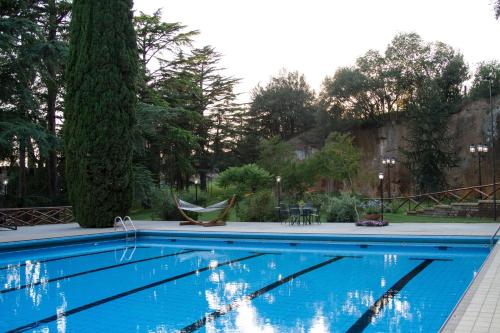 una piscina azul con una silla y un árbol en Residenza Antica Flaminia, en Civita Castellana