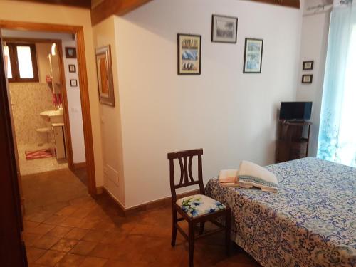 a bedroom with a bed and a chair in a room at Agriturismo Collelungo di Maremma in Diaccialone