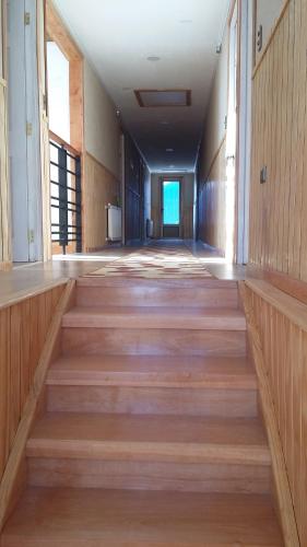an empty hallway of a building with wooden stairs at Hostal Los Teros in Coihaique