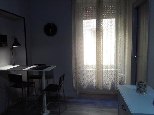 ナポリにあるMeridional Stationのテーブルと椅子、窓が備わる客室です。
