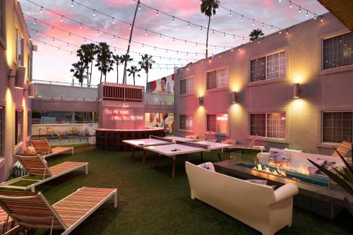 a room with chairs and tables and a building at The Kinney - Venice Beach in Los Angeles