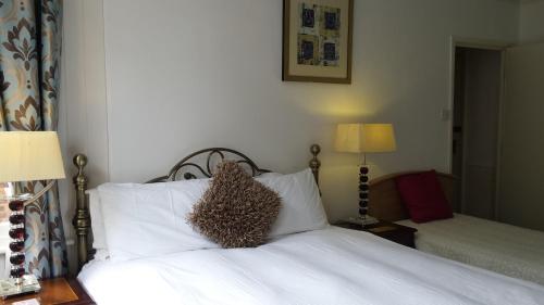 a bedroom with a bed with white sheets and two lamps at Shearwater in Bridlington