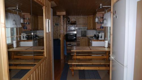 Una cocina con gabinetes y mesas de madera en un remolque. en Verlan Satumaa, en Verla