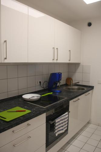 a kitchen counter with white cabinets and a sink at Wohnen auf Zeit am Golfplatz Motzen in Motzen