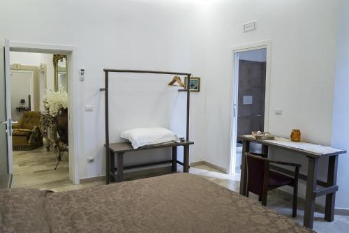 a bedroom with a bed and a desk and a table at B&B Conte Cavour in Barletta