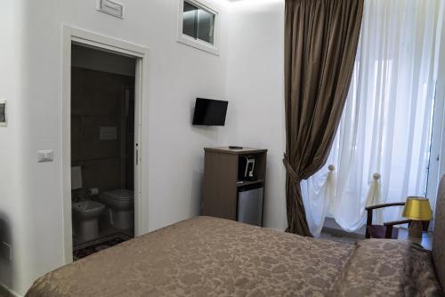 a bedroom with a bed and a bathroom with a toilet at B&B Conte Cavour in Barletta