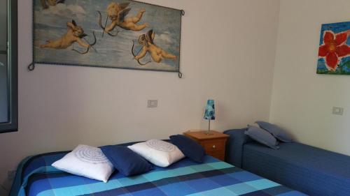 1 dormitorio con 2 camas y un cuadro en la pared en A Villa Ada b&b, en Arborea 