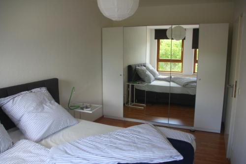 1 dormitorio con cama y espejo en Wohnen auf Zeit am Golfplatz Motzen, en Motzen