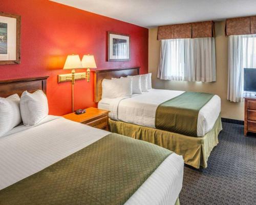 a hotel room with two beds and red walls at Quality Inn Ashland - Lake Superior in Ashland