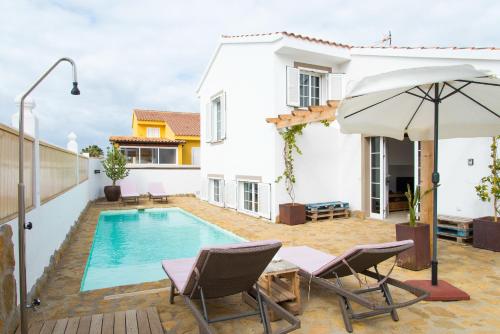 Villa mit einem Pool, 2 Stühlen und einem Sonnenschirm in der Unterkunft Villa Veronica in Corralejo