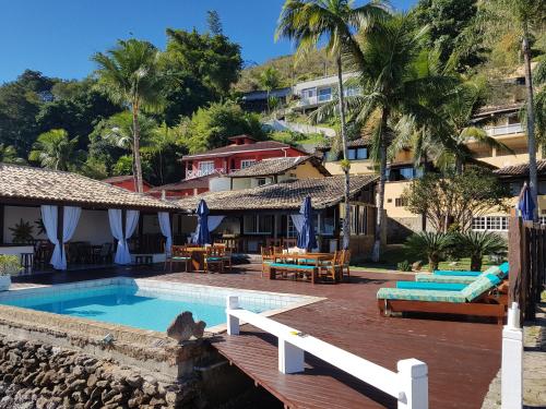 un complexe avec une piscine et une terrasse en bois dans l'établissement Pousada Costa do Sapê, à Angra dos Reis