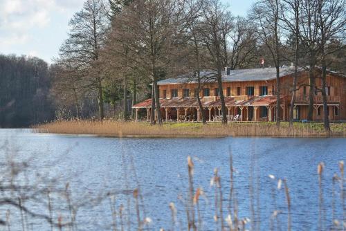 a large house sitting next to a body of water at Seehaus Hartwigsdorf in Klein Vielen