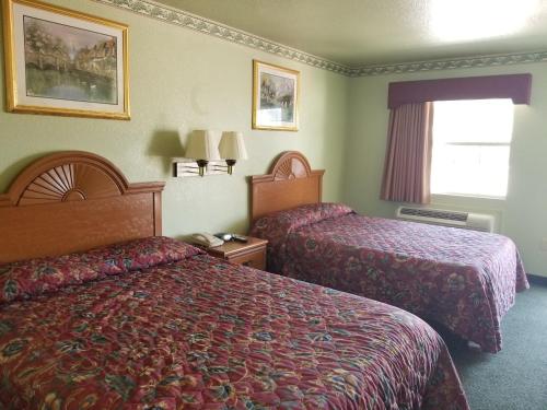 Habitación de hotel con 2 camas y ventana en Haltom Inn Fort Worth en Fort Worth