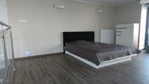 1 dormitorio con 1 cama y suelo de madera en Apartement - Loft Bydgoszcz Centrum en Bydgoszcz