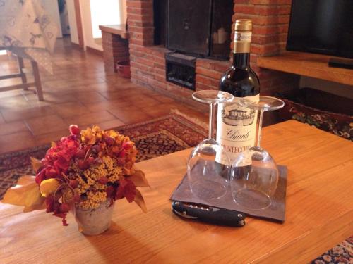 a bottle of wine and a vase of flowers on a table at Dolcevita Chianti Apartments in Radda in Chianti