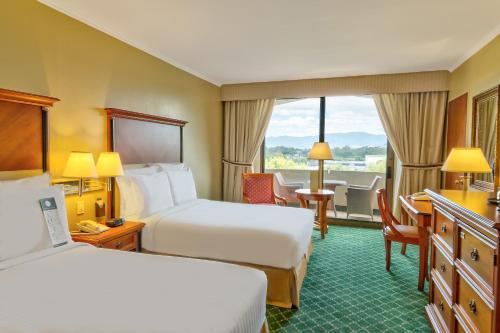 a hotel room with two beds and a balcony at Barceló Guatemala City in Guatemala