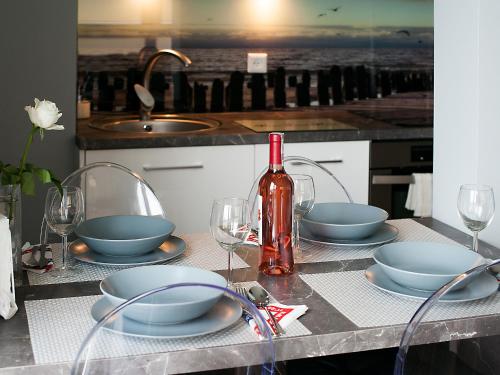 ヤストシェンビャ・グラにあるAmko Style Apartamenty Nadmorski 60 Willa Nordのテーブル(皿、グラス、ワイン1本付)