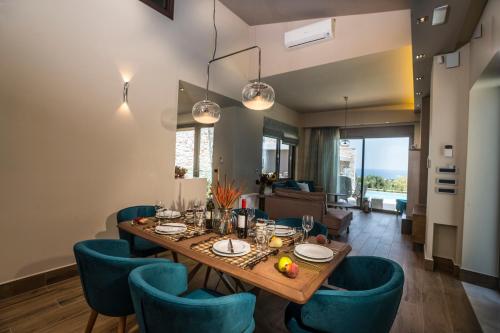 jadalnia ze stołem i niebieskimi krzesłami w obiekcie AA Luxury Villas w Kato Daratso