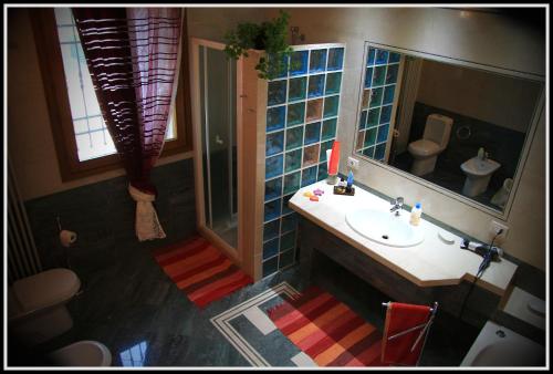 a bathroom with a sink and a toilet and a mirror at La Luce della Luna in Castelnovo Bariano
