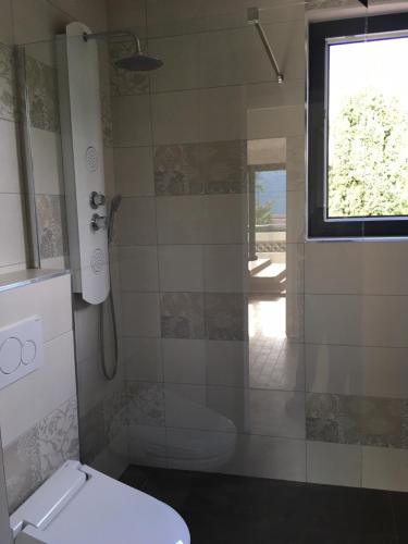 une salle de bain avec douche et toilettes et une fenêtre dans l'établissement Villa Eugénie, à Saint-Martin-du-Var