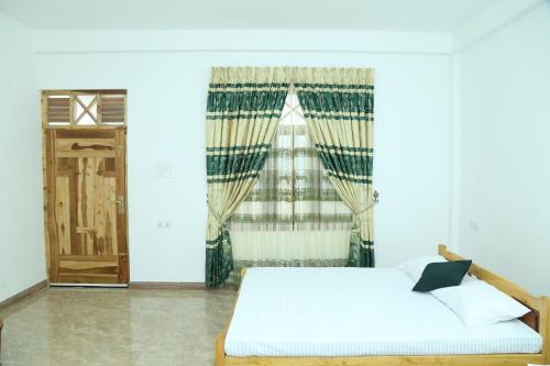 a bedroom with a bed and a window at Nilaveli Star View Hotel in Nilaveli