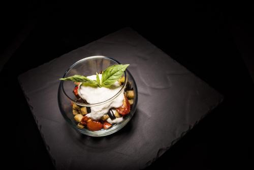 a glass dish with a dessert with a green leaf on it at Linder Cycling Hotel in Selva di Val Gardena