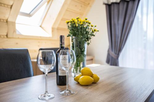 a bottle of wine and two glasses on a table at Giewont Residence in Kościelisko