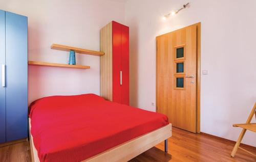 a bedroom with a red bed and a wooden door at Holiday House Barbara in Medulin