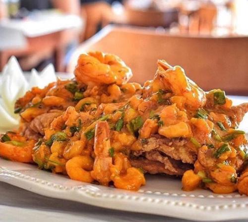 a plate of food with shrimp on a table at Pousada Recanto da Pedra in Iriri