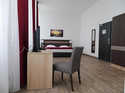 a bedroom with a bed and a desk and a chair at Ruhr Inn Hotel in Hattingen