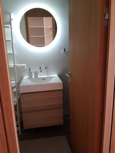 un baño con lavabo y espejo en Amber Wind Apartment, en Juodkrantė
