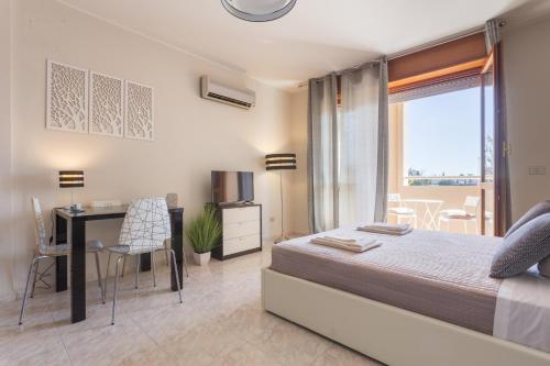 a bedroom with a bed and a desk and a window at Residenze Su Planu in Cagliari