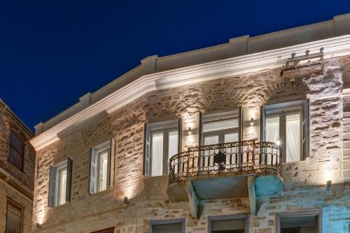 a building with a balcony on the side of it at 1844 Suites Syros in Ermoupoli